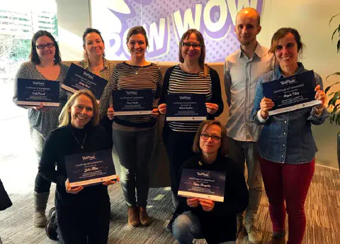 A group of women all proudly holding their certificates